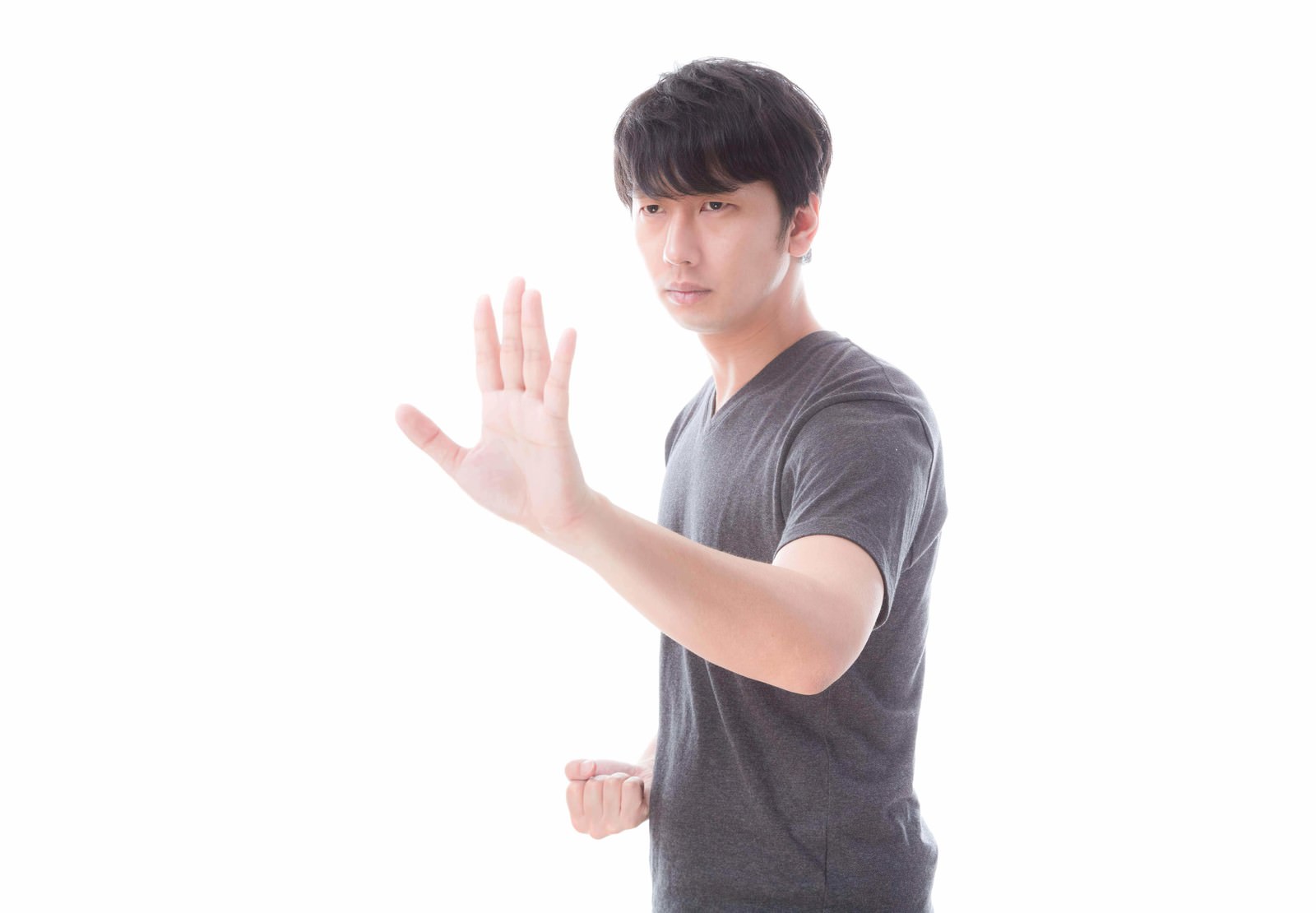 グレーのTシャツで左手を前に出し右手を構えるファイティングポーズの男性［モデル：大川竜弥］