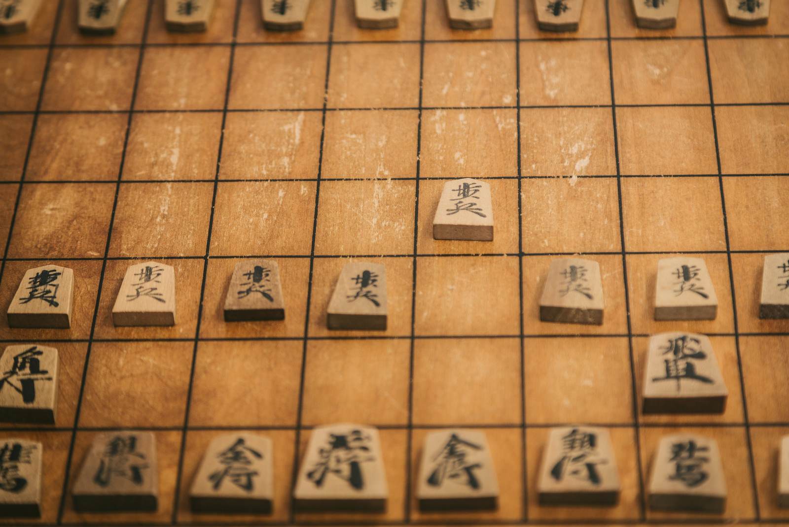 木製の将棋盤に整然と並べられた将棋駒