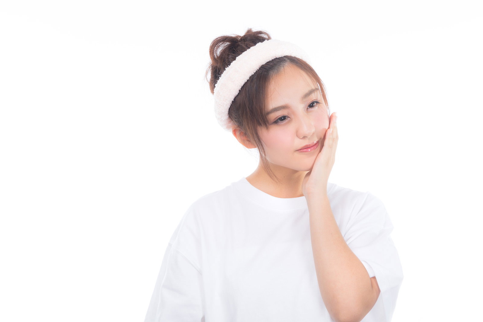 白い服を着た女性が頬に手を当てうっとりした表情をしている［モデル：河村友歌］