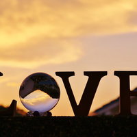 夕焼けに染まるLOVEと水晶玉のシルエットの写真