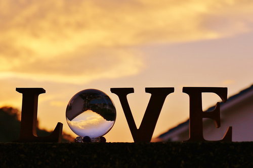 夕焼けに染まるLOVEと水晶玉のシルエット