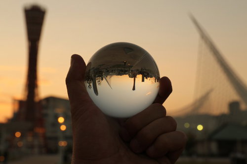 ガラス玉越しに映る神戸の夕焼けと夜景の街並み