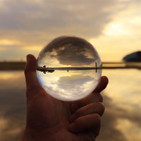 水晶玉に映る夕焼けの海岸の写真