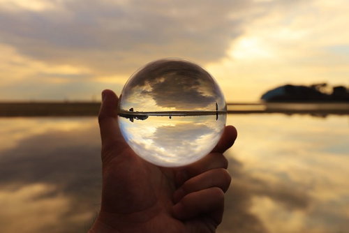 水晶玉に映る夕焼けの海岸
