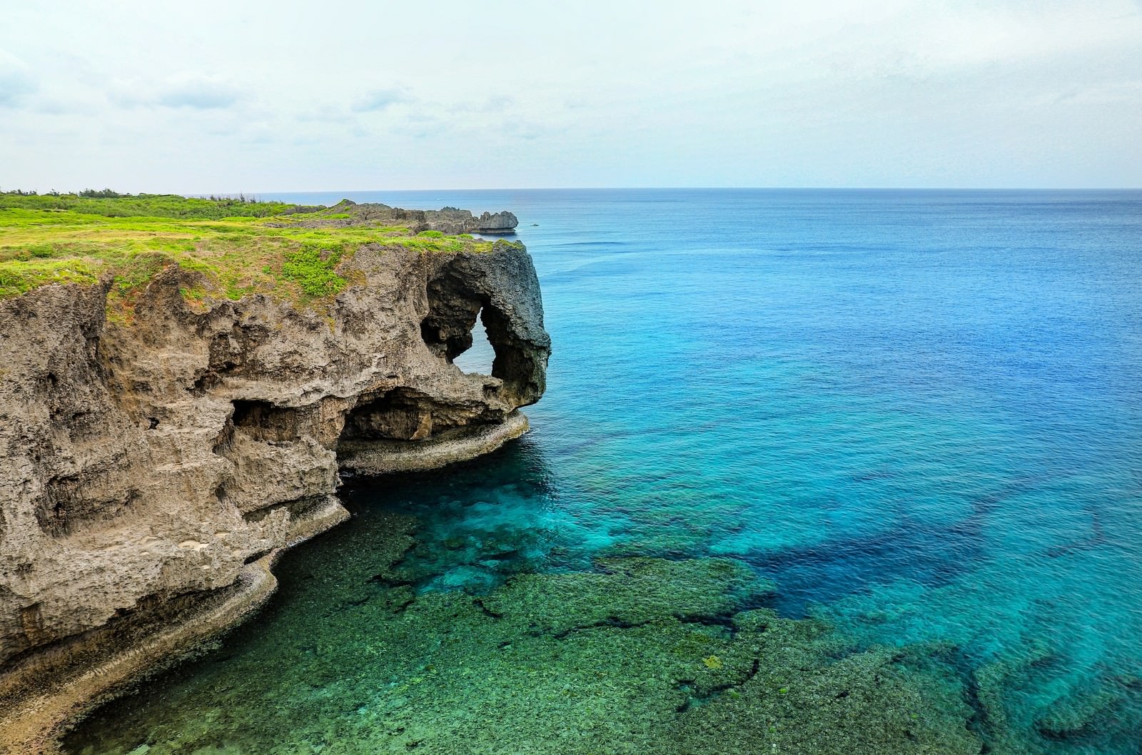 エメラルドブルーの透明な海と切り立った断崖絶壁の海岸風景
