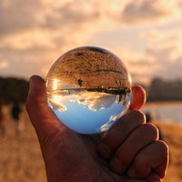 水晶球越しに見る夏の浜辺の夕景の写真