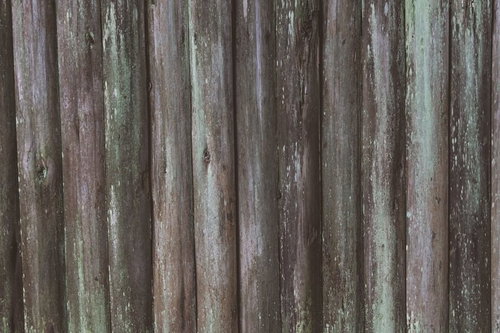 塗料が剥がれて緑や灰色が混じる古い木板のテクスチャー