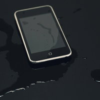 水滴がついたスマートフォンと地図画面の写真