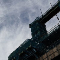 薄暗い建設現場の鉄骨構造物と足場の風景の写真