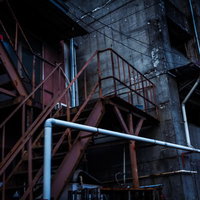 年期の入った工場の夜間風景。赤錆びた鉄骨階段の写真