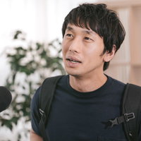 インタビューを受ける大学生風の男性の写真