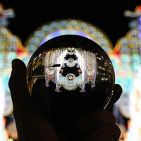 水晶玉越しに見る色とりどりのイルミネーションの写真