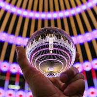 ガラス玉に映り込む円形のイルミネーションの輝きの写真