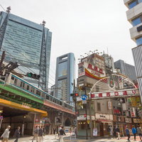 新橋西口通り駅前の繁華街交差点の古い雑居ビルと人通りの写真