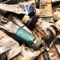 使い込まれた油絵具チューブの山の写真