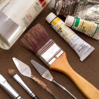 布の上に並ぶ油絵のセット一式の写真