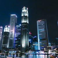 シンガポールの高層ビル群の夜景。川に映る摩天楼のライトアップの写真