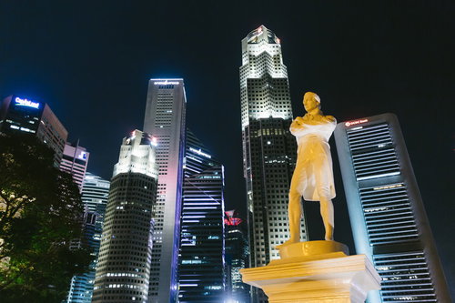 ラッフルズ像とライトアップされたビル群の夜景