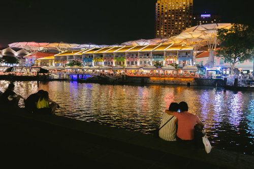 夜景が映る水辺で手をつなぐカップル（シンガポール）