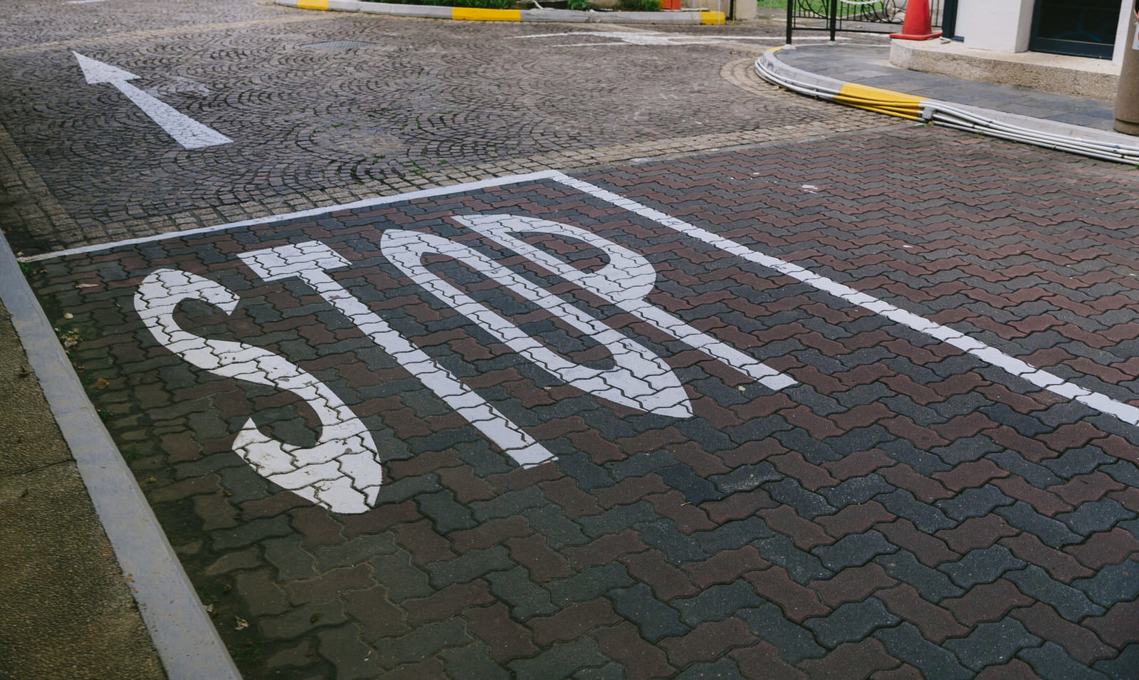 駐車場の路面に描かれた白いSTOP標識