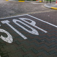 駐車場のアスファルトに描かれた白いSTOP標識の写真
