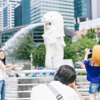 マーライオンパークの噴水で記念撮影する観光客の写真