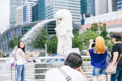 マーライオンパークの噴水で記念撮影する観光客