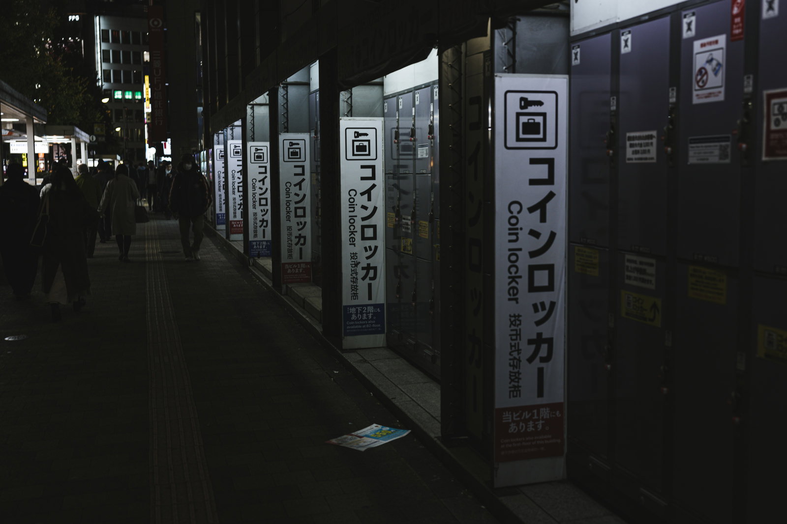 西新宿ヨドバシ横の夜間に照らされたコインロッカーが並ぶ歩道