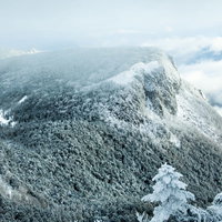 厳冬期の稲子岳で沸き立つ雲海と雪化粧した山々の写真