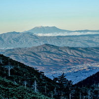 晩秋の山々と霞む空の御嶽山の写真