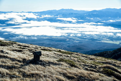 硫黄岳の山頂付近にある祠と雲海に包まれた八ヶ岳連峰