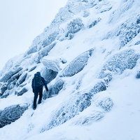 厳冬期の積雪斜面をトラバースする登山者の冬山登山風景の写真