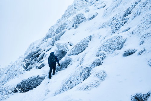 厳冬期の積雪斜面をトラバースする登山者の冬山登山風景