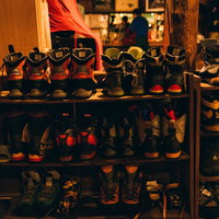 山小屋の木製靴棚に並ぶトレッキングシューズと登山靴の写真