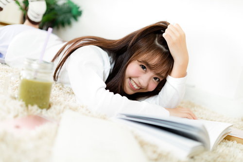 リラックスして休日を過ごす彼女、グリーンスムージーを片手に読書