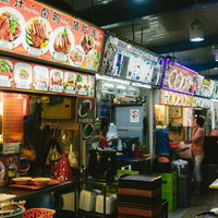 シンガポールの屋台村ホーカーセンターで営業する飲食店街の写真