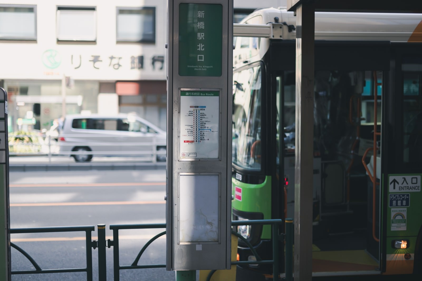 新橋駅北口のバス停に緑色のバスが停車している様子