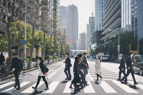 高層ビルが立ち並ぶオフィス街の横断歩道を渡る人たち