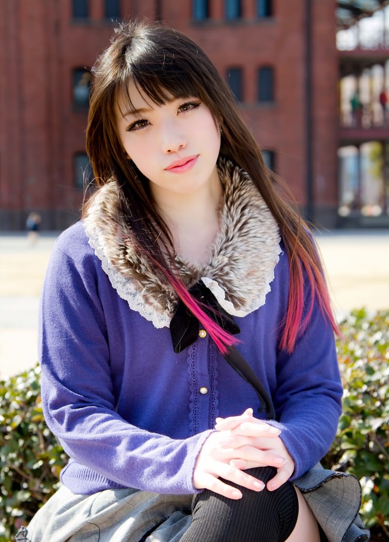 赤レンガ前で足を組む女性［モデル：大和くるみ］