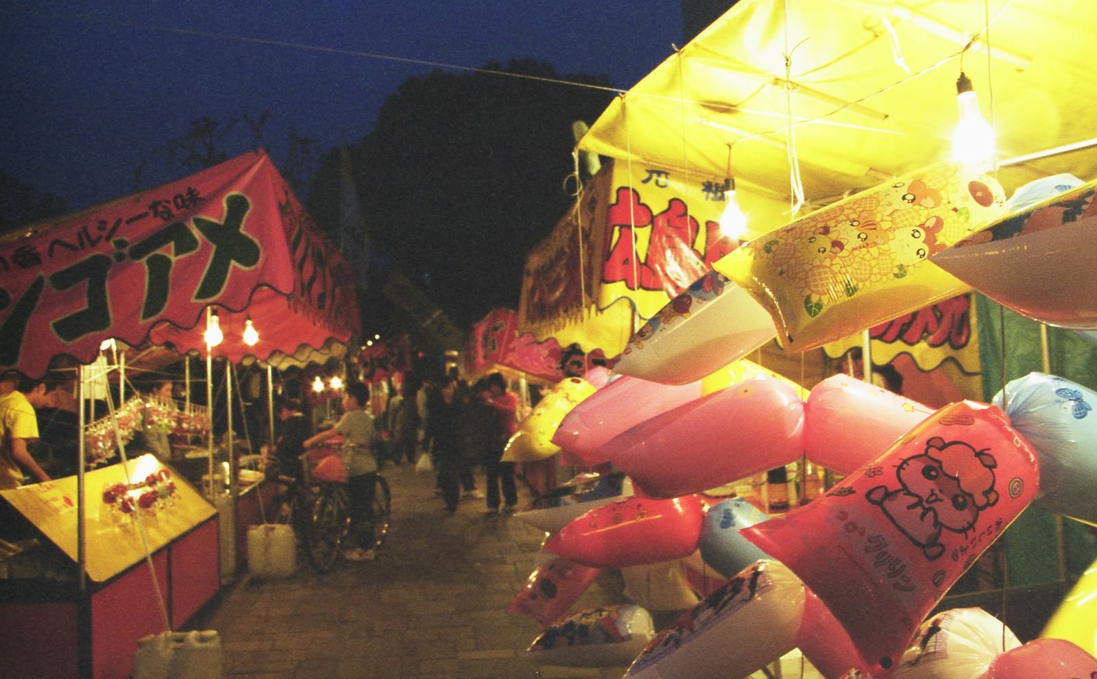 夜の祭り会場で明るく照らされた屋台の風景