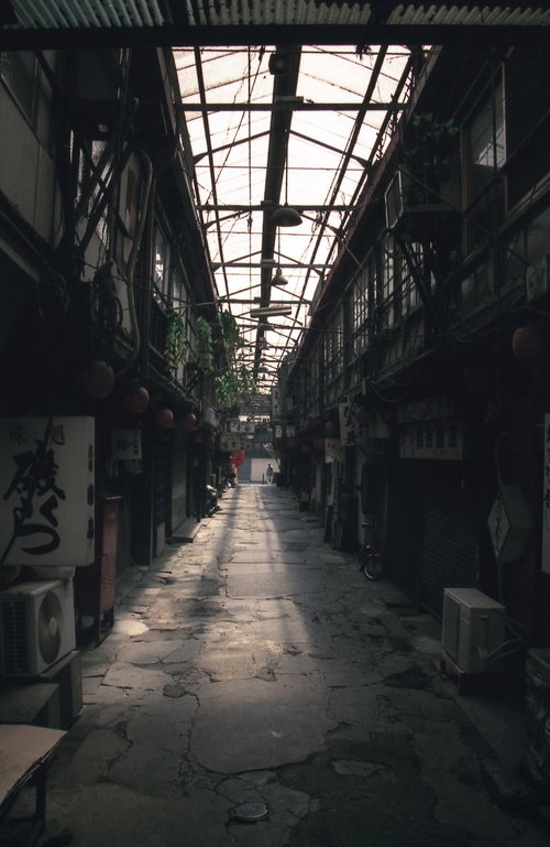 裏路地に射し込むアーケードの光と石畳の情景