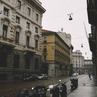 雨上がりの濡れた石畳の路地に停められたバイク（イタリア ミラノ）の写真