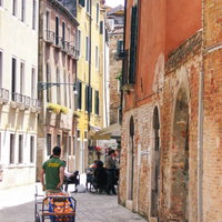 ベネチアの石畳の街並みで果物を売る青年（イタリア）の写真