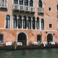 ヴェネツィアの水路沿いにあるレストランの白いテラス席の写真