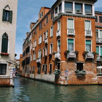 ヴェネツィアの水路沿いに建つオレンジ色のレンガ造りの建物（イタリア）の写真
