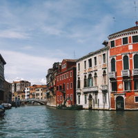 ヴェネツィアの水路に浮かぶ小船と赤レンガの街並み（イタリア）の写真