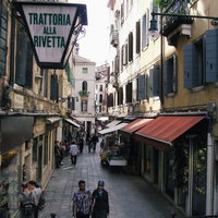 ヴェネツィアの石造りの路地でショッピングを楽しむ観光客たち（イタリア）の写真