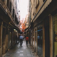 ヴェネツィアの路地裏を行き交う観光客と歴史的な街並み（イタリア）の写真