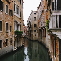 レンガ造りの建物沿いを流れるヴェネツィアの水路の写真