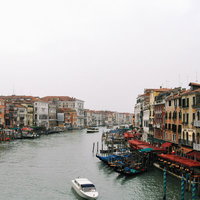 ヴェネツィアを流れる運河の船着場に浮かぶゴンドラと小船の写真